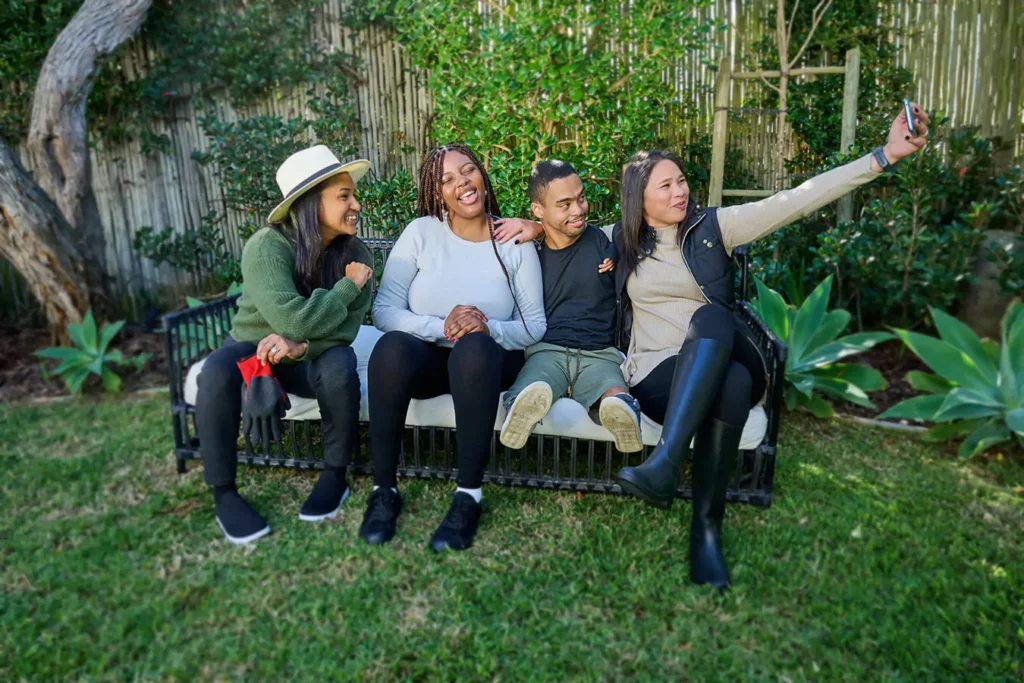 Group of diverse friends sitting outside taking a photo together